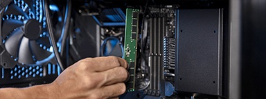 A hand installing Kingston memory in a desktop PC