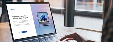 Руки на ноутбуке проверяют уведомление о завершении поддержки Windows 10 в обновлениях системы Windows