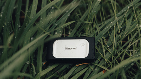 Un disco SSD externo Kingston XS2000 en un prado.