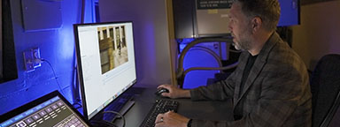 Digital Projectionist Ryan Carpenter sitting at a computer monitor.
