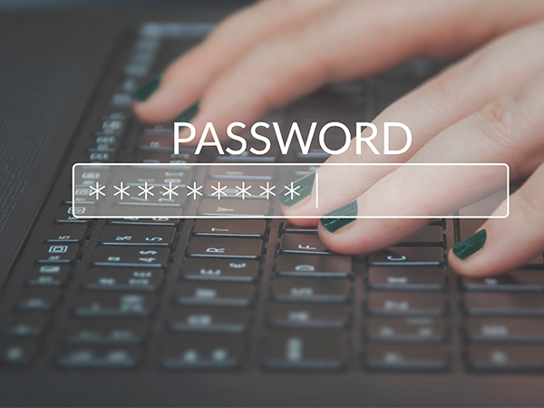 Hands typing on a keyboard with a password field with asterisks
