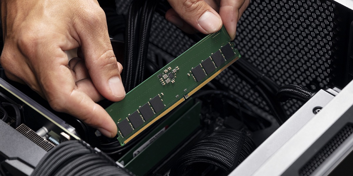 A hand installing Kingston memory in a desktop PC