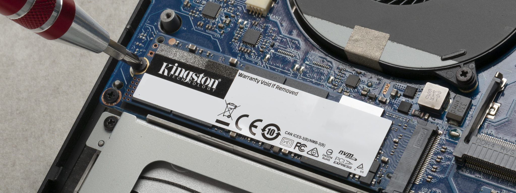 Ổ SSD M.2 của Kingston đang được lắp đặt vào máy tính xách tay