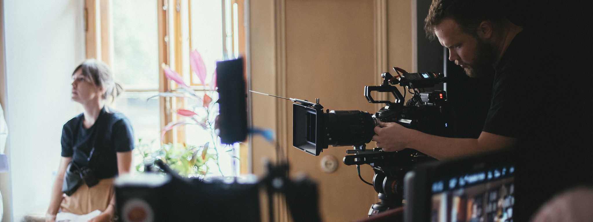 Professioneller Videofilmer bei Filmaufnahmen in einem Gebäude