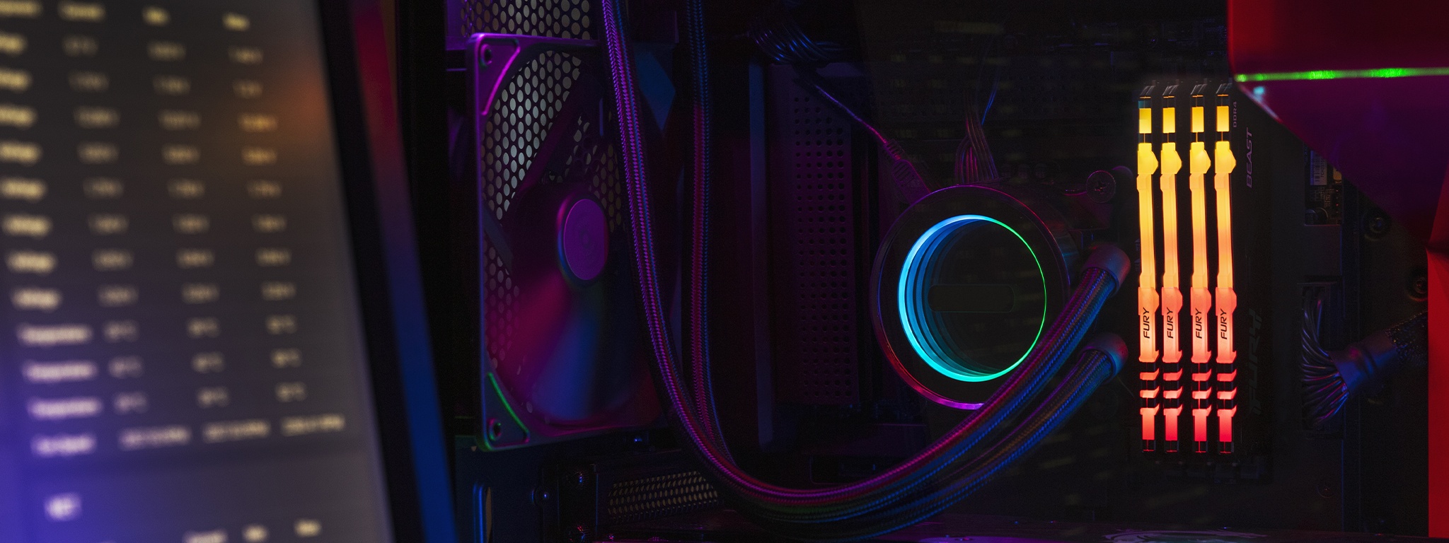 Kingston FURY Beast RGB mit einem CPU-Lüfter und in einem Motherboard eingesteckten Kabeln, mit Monitor auf der linken