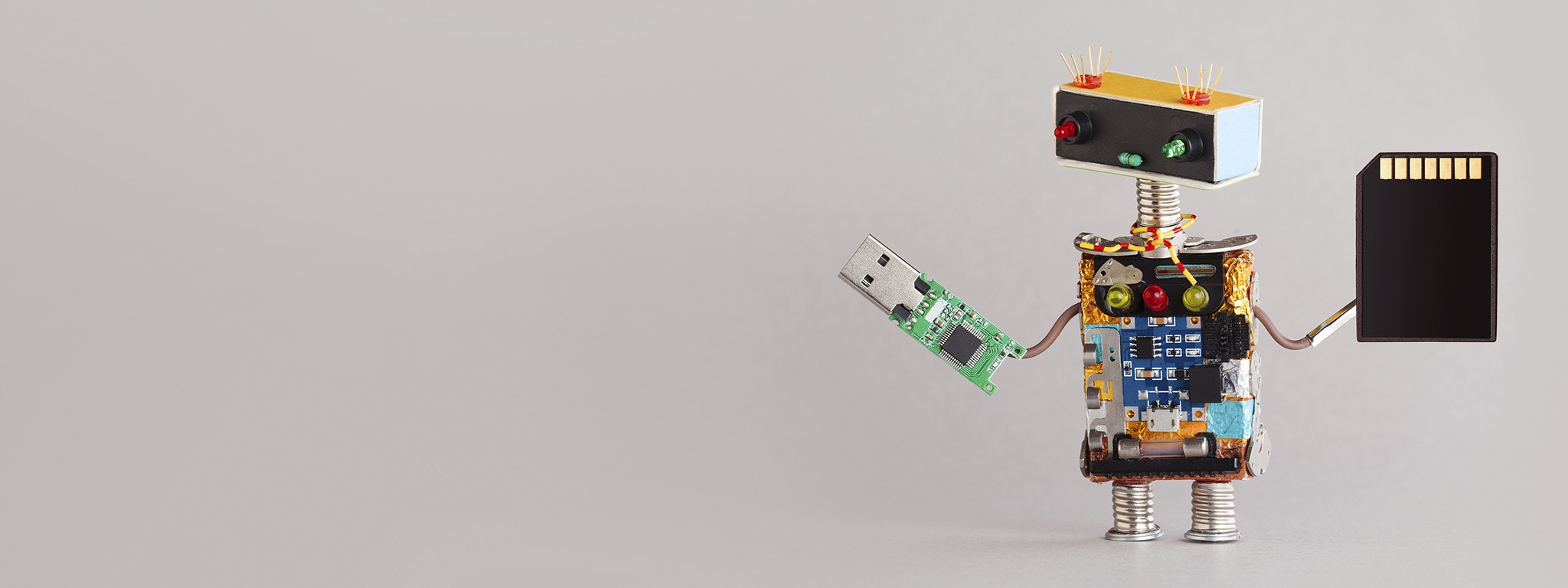 Robot DIY thu nhỏ đang cầm bảng ổ đĩa USB Flash và thẻ nhớ SD