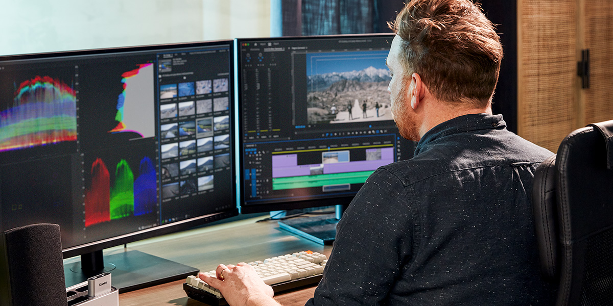 Kingston offers the means to future-proof your machine with cutting-edge memory and storage that offers superior performance and reliability. A tech professional working on a video at a desk with two monitors, in front of a window with several indoor plants.